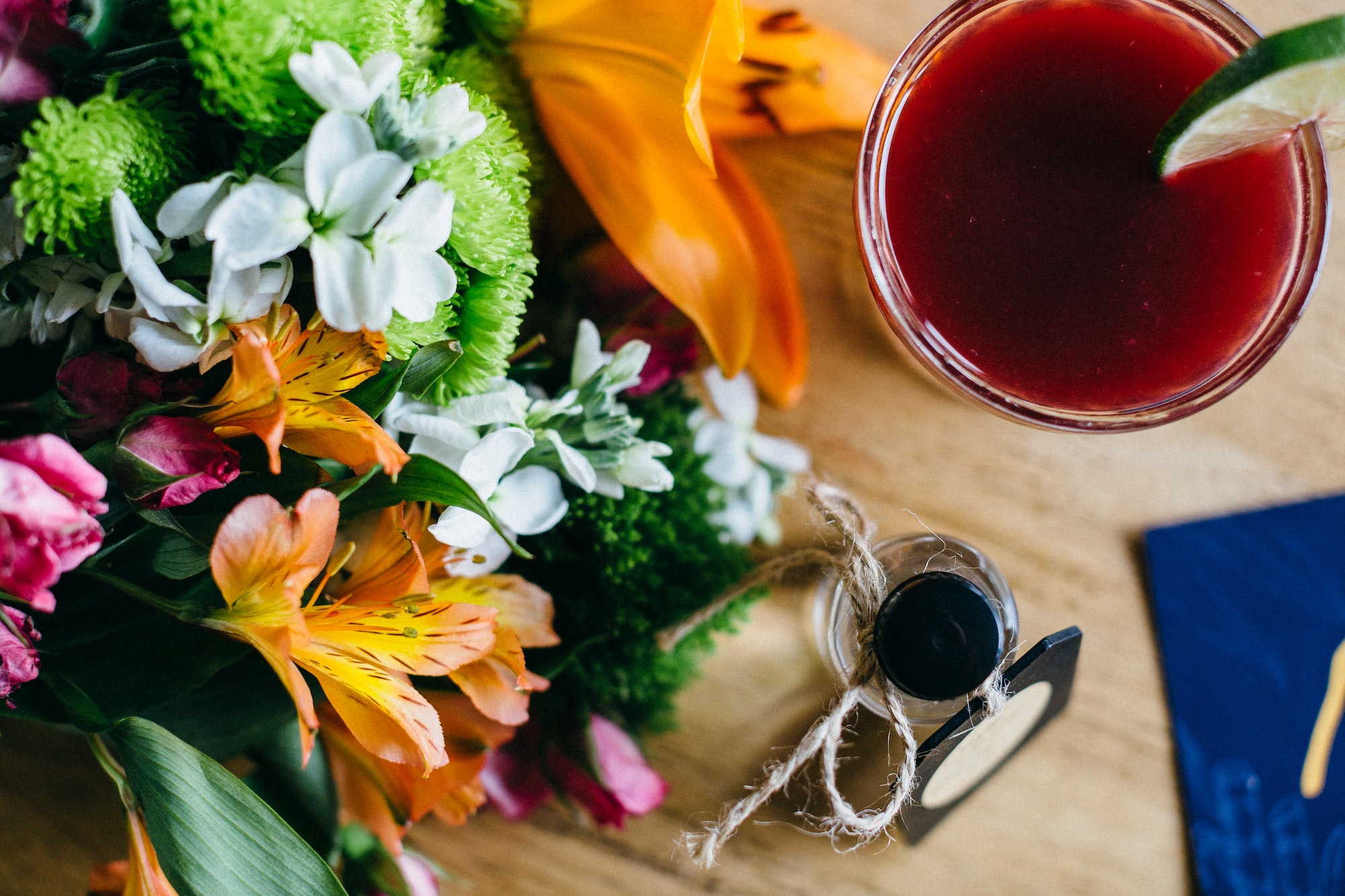 Ruby Red Cocktail Next to a Colorful Bouquet